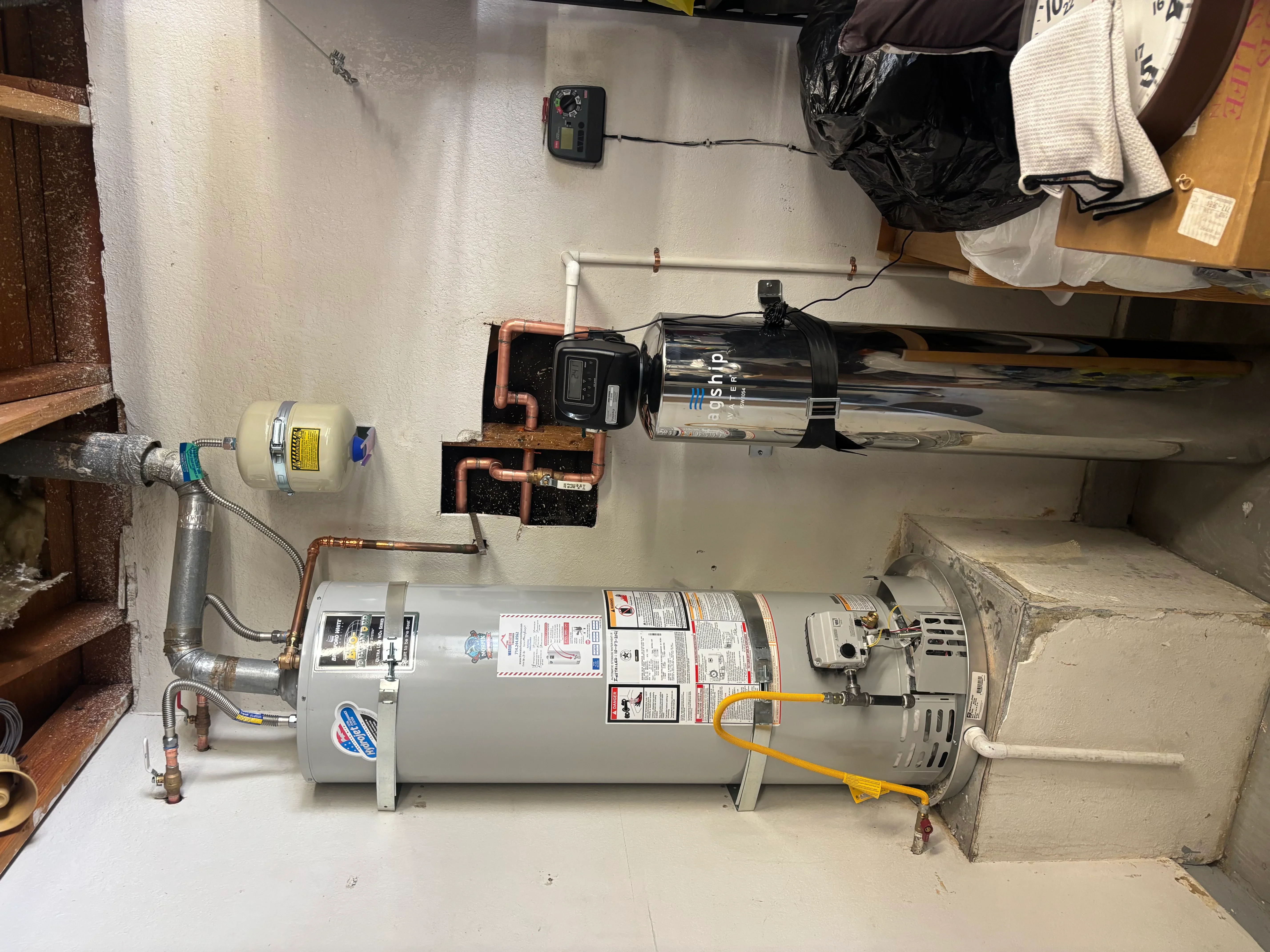 Gas water heater with copper piping, expansion tank, and wall-mounted recirculation pump system