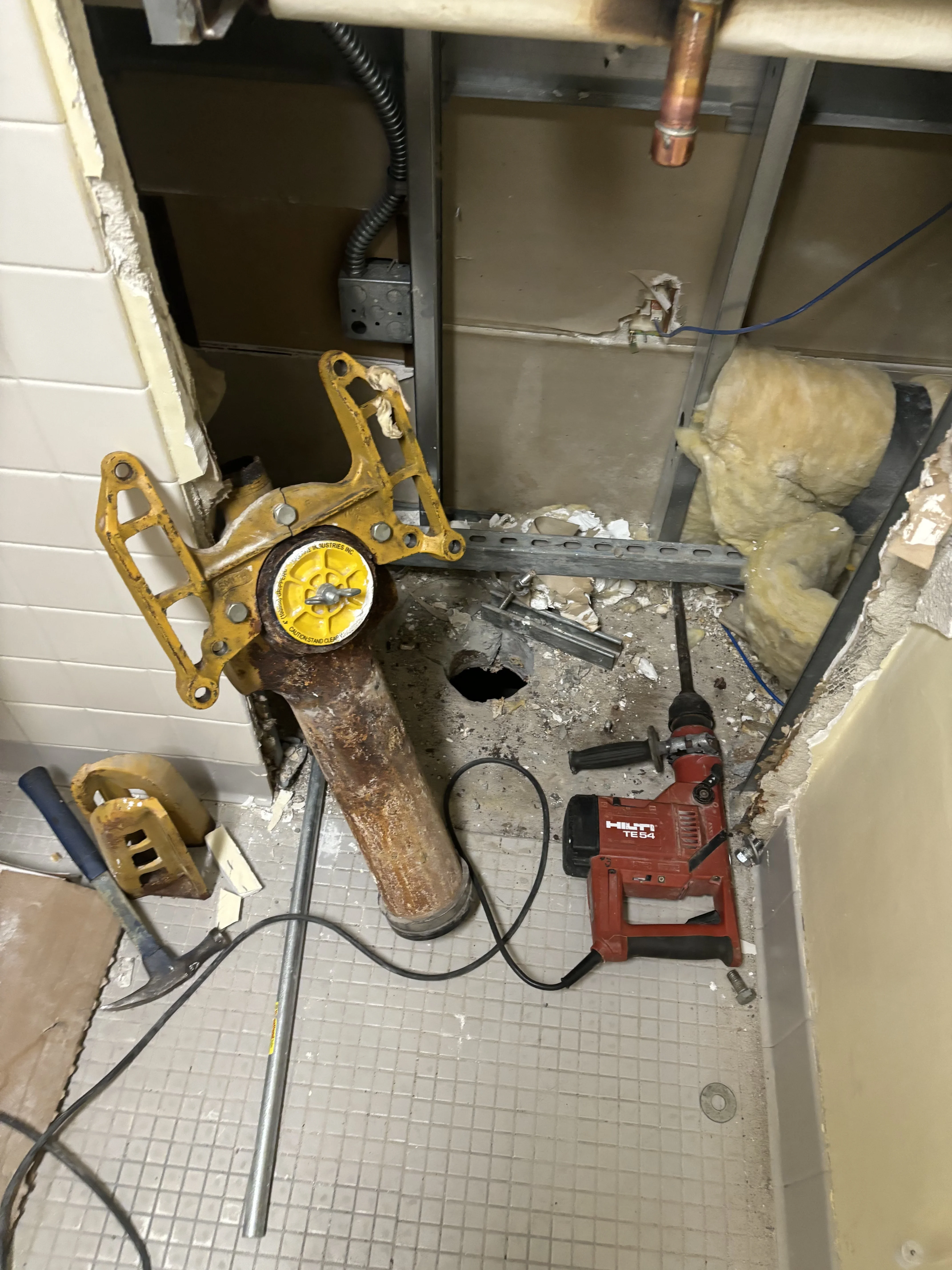 Basement plumbing rough-in with copper lines, drainage pipes, and mechanical equipment installation